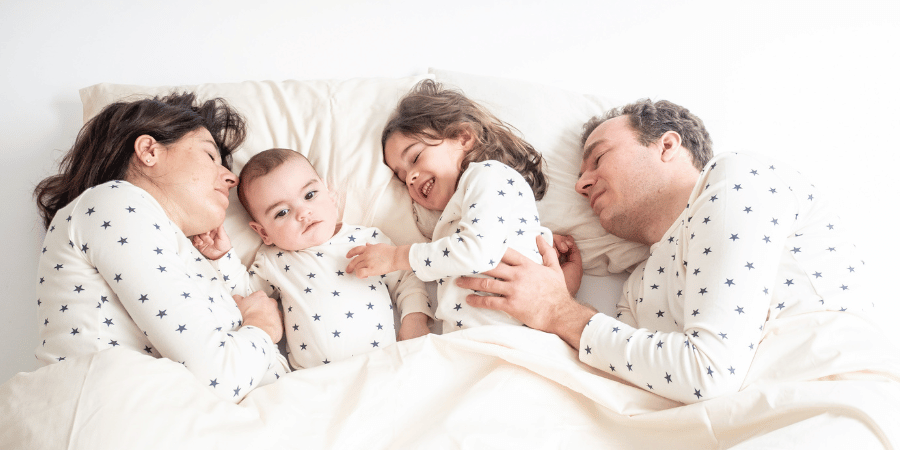 Familie im Bett gibt Kindern eine Massage