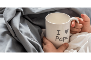 holding a cup while resting in bed