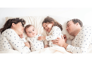 Parents massaging their children in bed