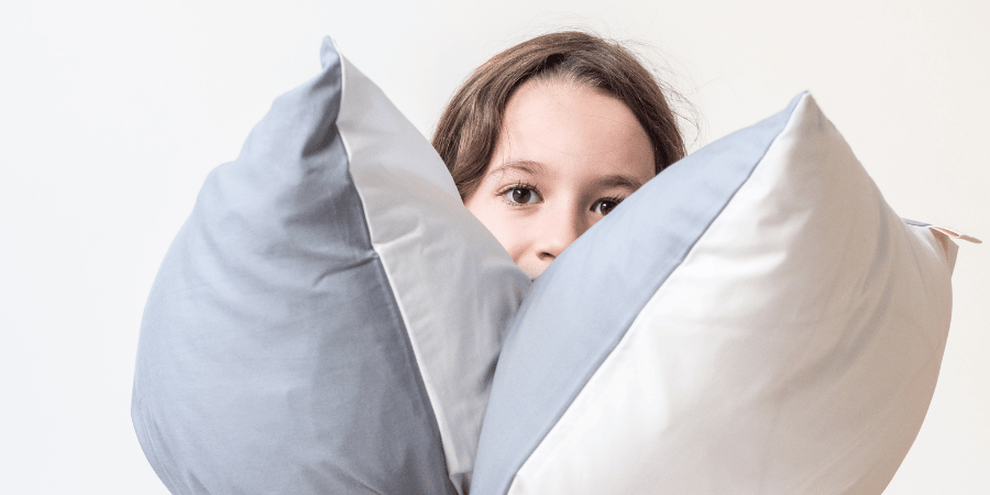 little girl holding 2 Zizzz pillows