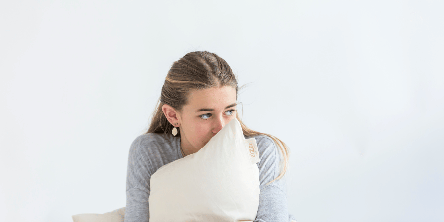 woman holding her Zizzz pillow