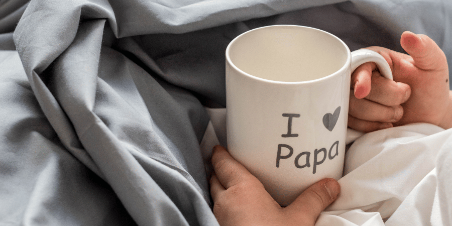 holding a cup while resting in bed